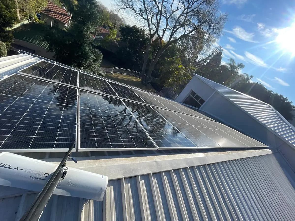 Waterkloof rooftop after rain: professionally cleaned solar panels on the left, still dirty on the right